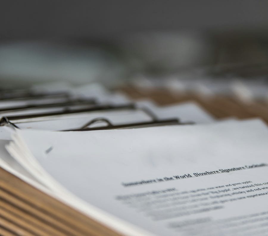 A close-up of a person analyzing blue graph data with a yellow pencil.